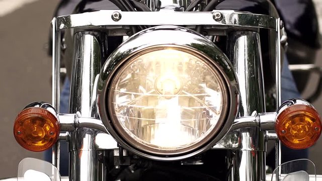 Close-up view of headlights of a modern motorcycle, camera movement from the bottom up.