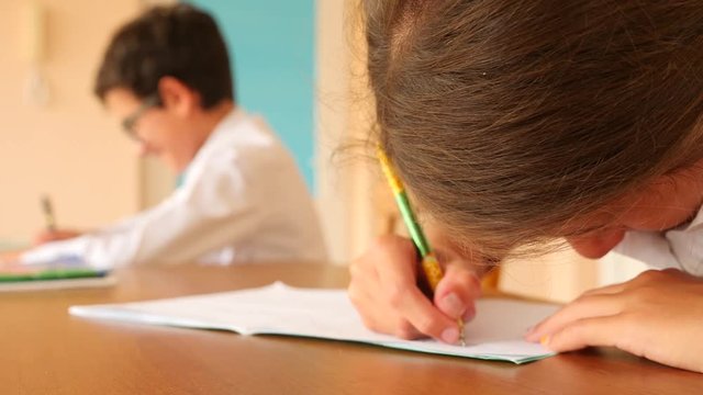 education, people and learning concept - group of students with notebooks writing test at school. 4k. Slow motion