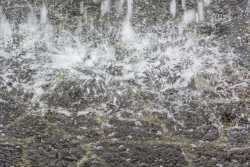 Impacting geyser of water on concrete.