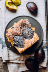 Homemade pie with plums on the wooden table background. Fruit autumn cake with cinnamon. Top view