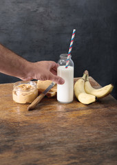 Bottle of milk with peanut paste, toast and bananas