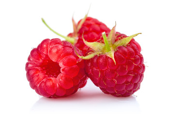 Fresh red raspberries with green leaves isolated on white