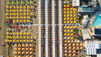 Drone aerial view of the umbrellas and gazebos on Italian sandy beaches. Adriatic coast. Emilia Romagna region.