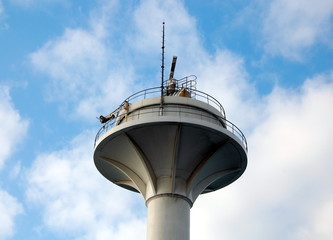 Fototapeta na wymiar Radar tower against the sky with clouds