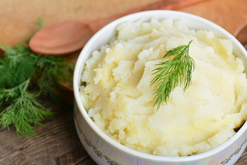 Mashed potatoes, boiled puree in ceramic pot on wooden background