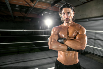 Fototapeta na wymiar Serious dramatic tough mma fighter with arms crossed looking mean and intimidating
