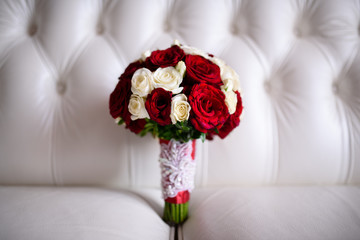 Beautiful wedding bouquet of Red Roses on a white couch.