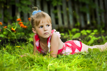 The little girl in a bathing suit in a garden
