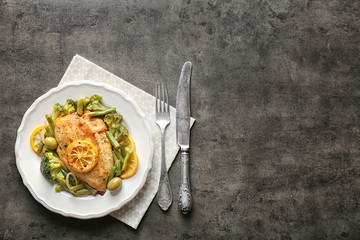Plate with delicious chicken fillet and sliced lemon on table