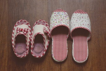 home slippers of mother and daughter on hard wood floor, filtered tones