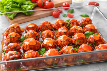 Delicious turkey meatballs in glass casserole dish on light table