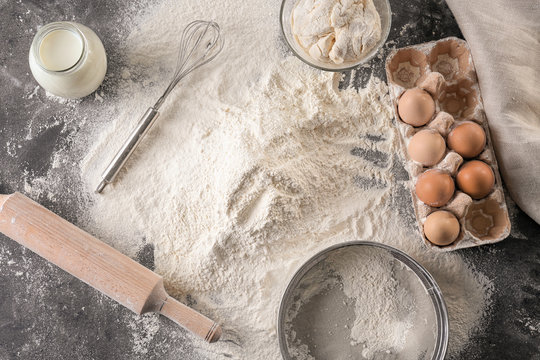 Composition with heap of flour on kitchen table