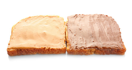 Bread slices with creamy peanut butter on white background