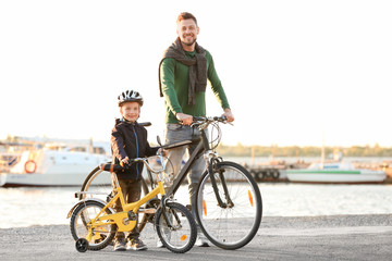 Obraz premium Dad and son standing with their bicycles outdoors