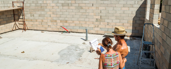 couple regardant le plan de leur future maison