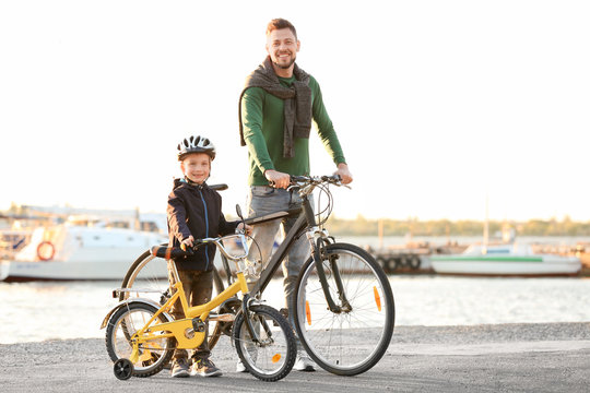 Dad and son standing with their bicycles outdoors
