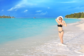 Beautiful young woman on sea beach at resort