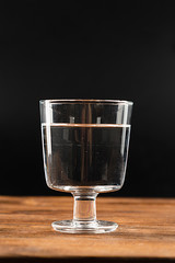 A glass of clean water on an old wooden background