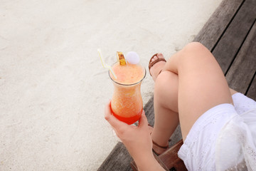 Young woman with tasty cocktail at resort