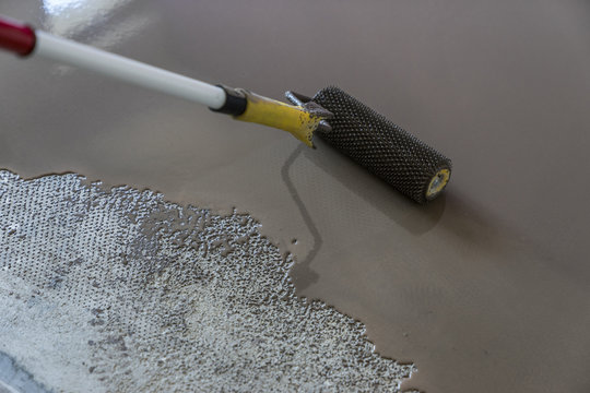 Interior of house under construction. Roller application. Floor