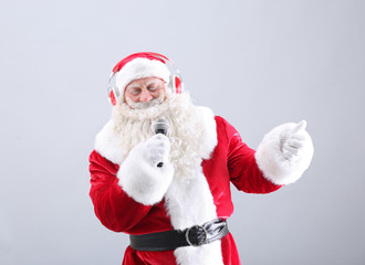 Santa Claus singing Christmas songs on light background