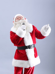 Santa Claus singing Christmas songs on light background