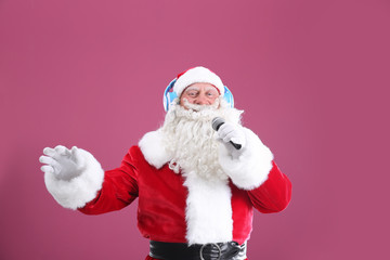 Santa Claus singing Christmas songs on color background