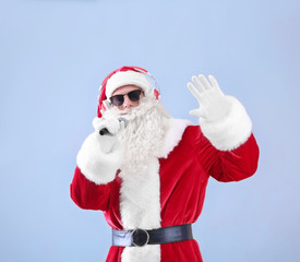 Fototapeta na wymiar Santa Claus singing Christmas songs on light background