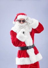 Santa Claus singing Christmas songs on light background