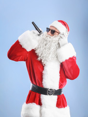 Santa Claus singing Christmas songs on color background