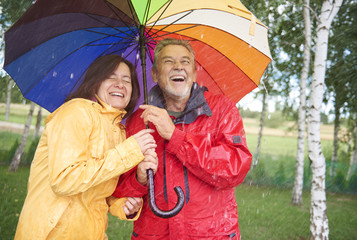 Couple looking for shelter with umbrella
