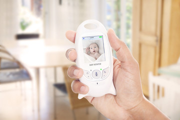Parent monitoring baby through baby monitor