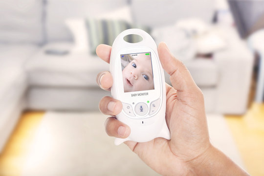 Parent monitoring baby through baby monitor