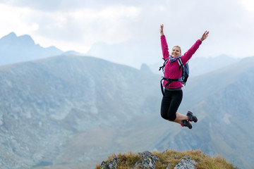 Woman jumping for joy on mountain top