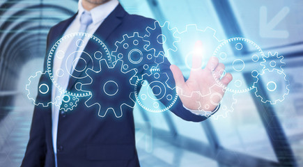 Businessman touching technology interface with gear wheel setting