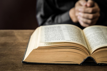 Naklejka premium Opened bible in the quiet, dark atmosphere. Prayer time on sunday.