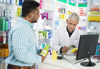 Obraz premium Chemist Scanning Product's Barcode While Customer Standing At Co