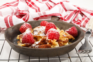 kaiserschmarrn with raspberries in a cast iron pan