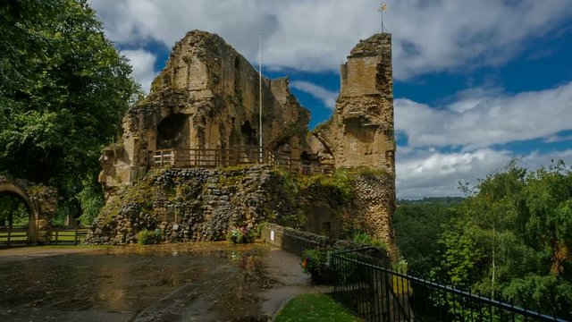 Panning shot of the Knaresborough Castle progressively lit by beautiful sunlight against a dramatic sky in Yorkshire, England, UK