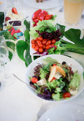 Plates with salad and vegetables put on dinner table