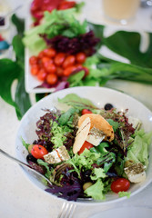 Plates with salad and vegetables put on dinner table