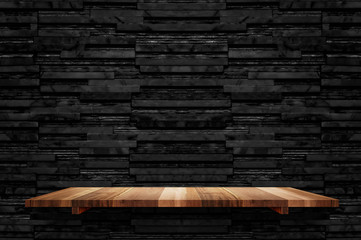 Empty brown plank wood shelf at black layer marble tile wall background,Mock up for display or...