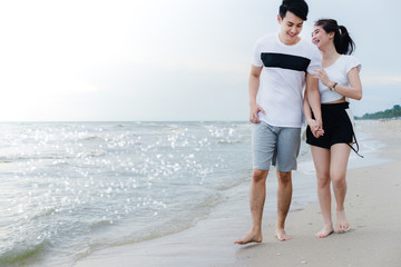 Young man walking talk with girl at beach, couple having fun