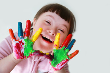 Cute little down syndrome girl with painted hands. - 168167906