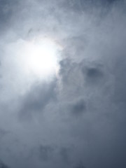 Grey dark cloudy sky with the sun, vertical