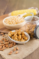 Corn kernels in wooden plates and popcorn with Caramel and almond cream on wooden table