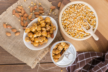 Corn kernels in wooden plates and popcorn with Caramel and almond cream on wooden table