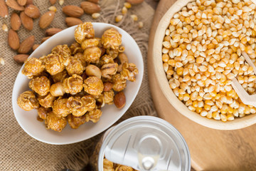 Corn kernels in wooden plates and popcorn with Caramel and almond cream on wooden table