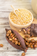 Corn kernels in wooden plates and popcorn with Caramel and chocolate cream on wooden table