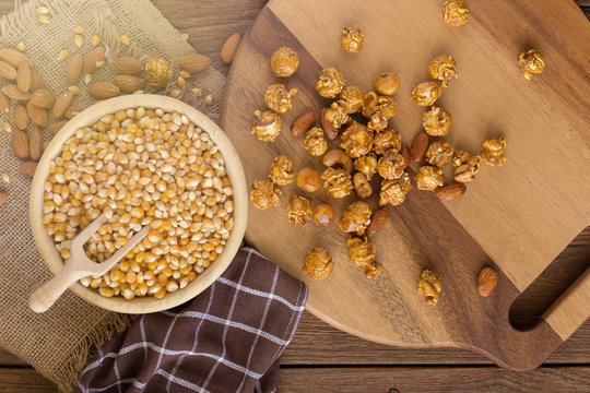 Corn kernels in wooden plates and popcorn with Caramel and almond cream on wooden table